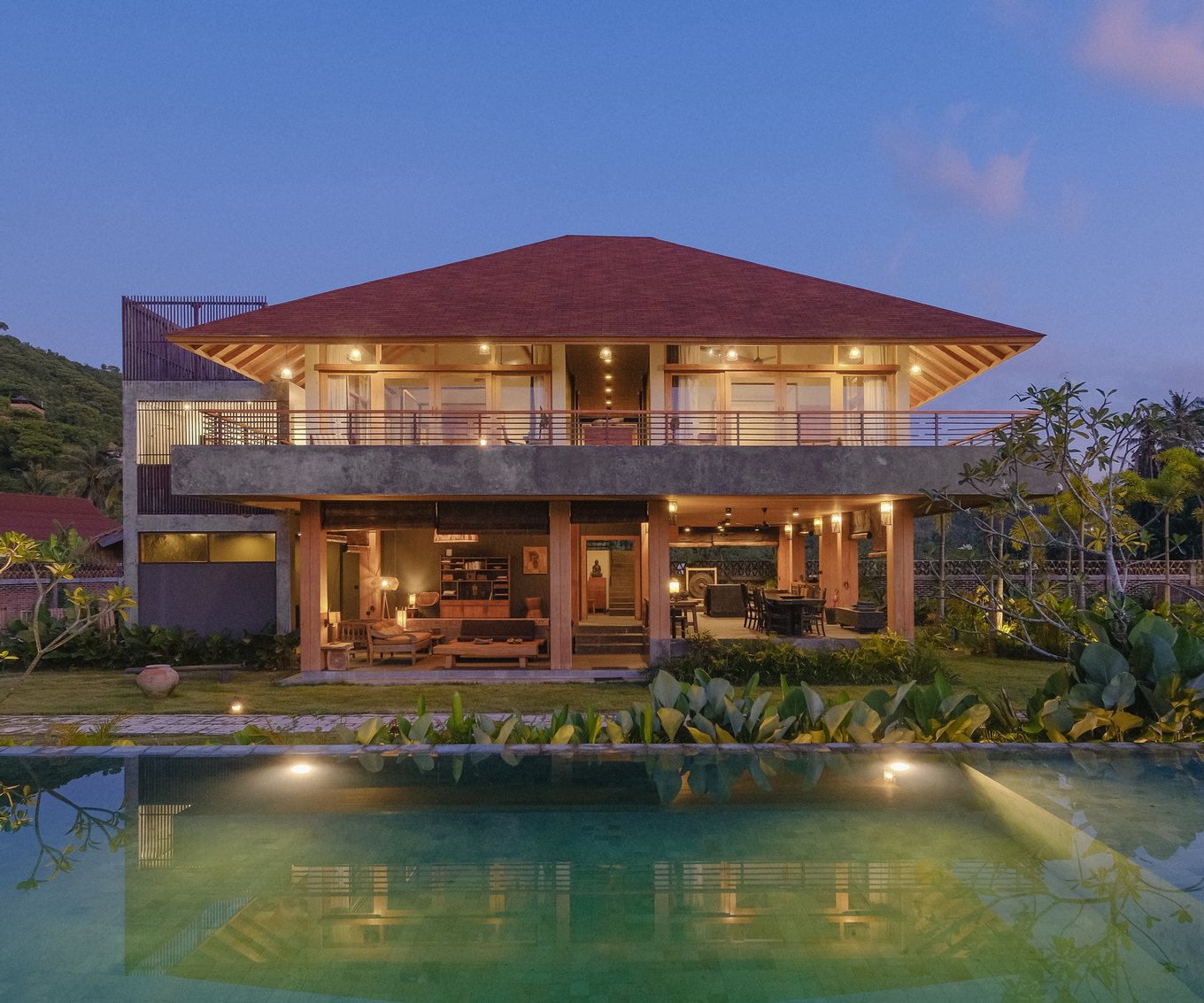 the amigos lombok villa at dusk, lights on, the pool in front