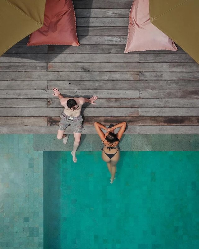 two people at the edge of the villa pool in lombok, from above
